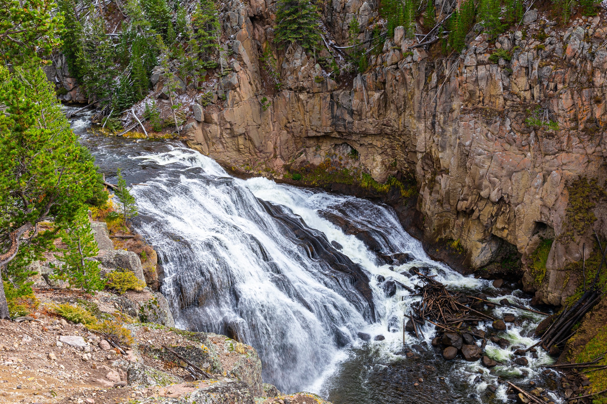 Waterfall cascading down rocky cliffs in Yellowstone National Park